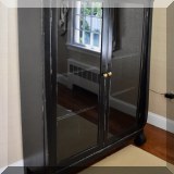 F25. Black painted bookcase with siding glass doors. 58”h x 45”w x 14”d 